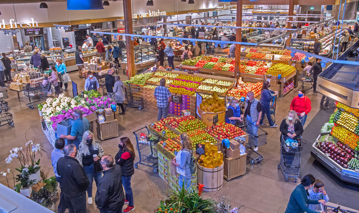 Store manager Ginger Henderson said about 200 customers came through the doors of Gig Harbor’s Metropolitan Market in the first half-hour and the opening day bustle was still evident hours later in the produce area Thursday, Oct. 7, 2021. At top is a row of speciality food areas brimming with ready-made and to-go items.