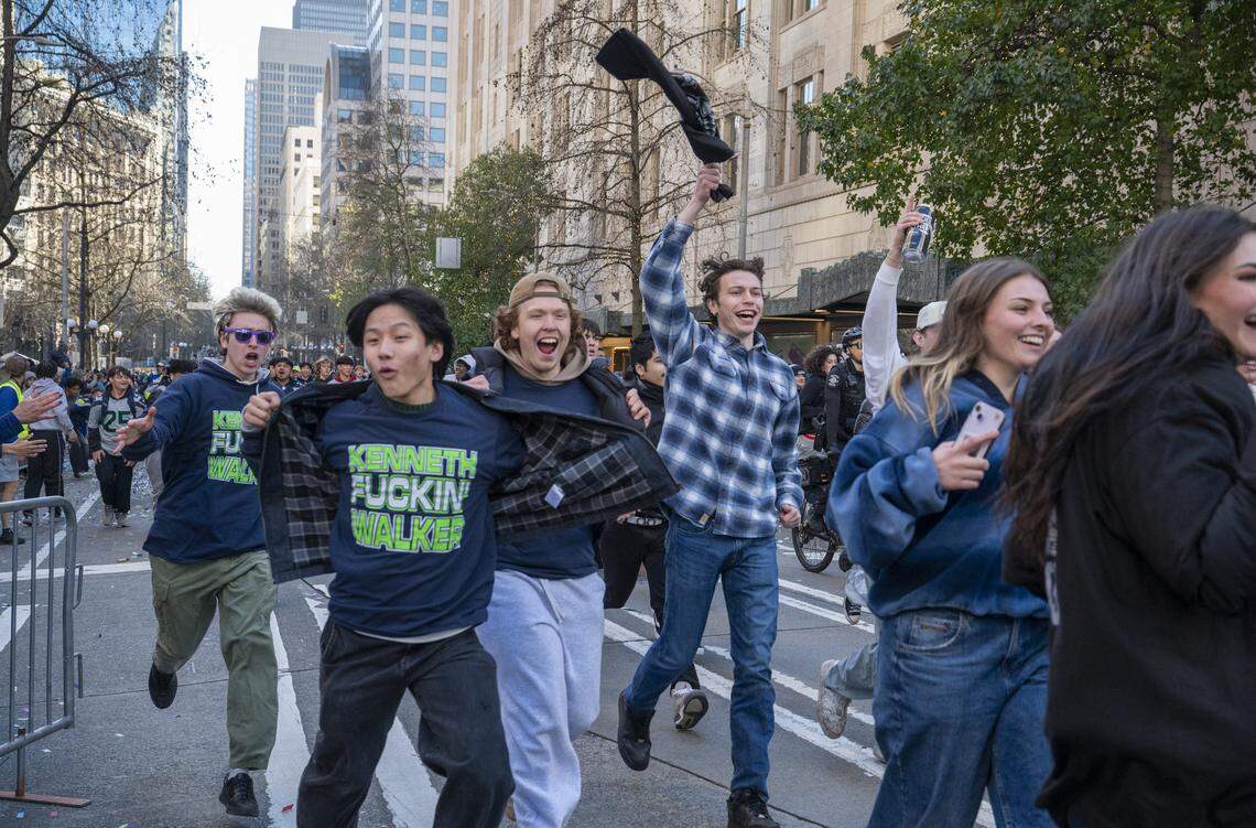 Fans run into the street after the Super Bowl parade through downtown on Wednesday, Feb. 11, 2026, in Seattle.