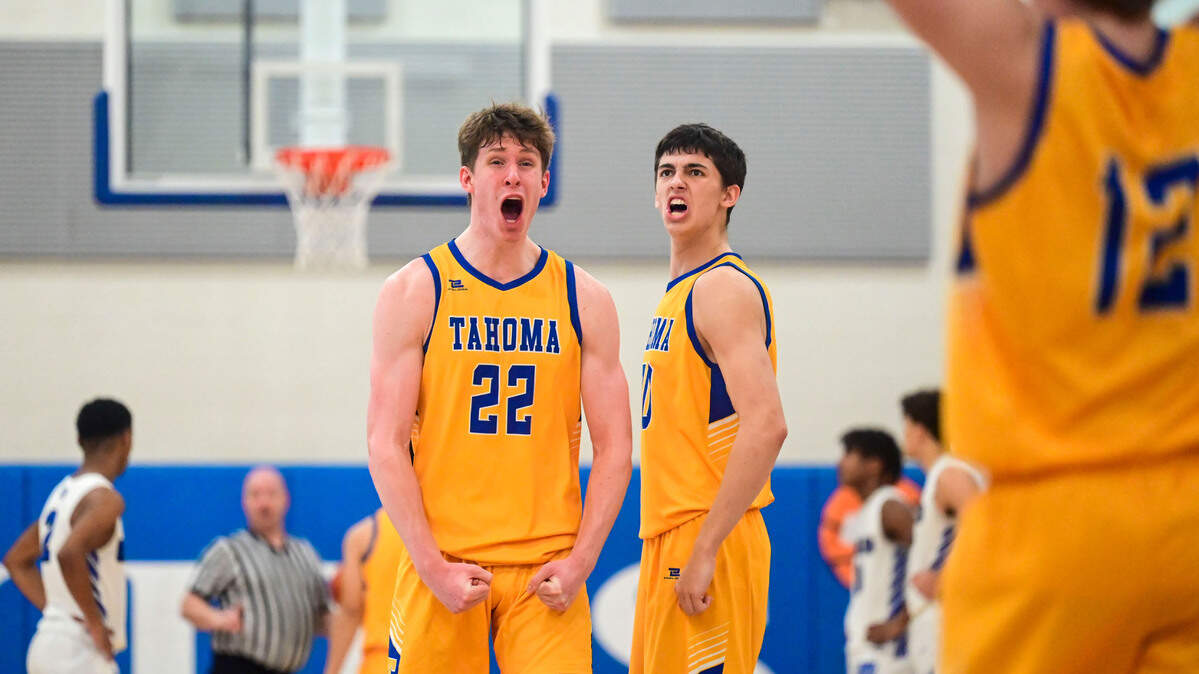Tahoma forwards Cooper Church (22) and Carson Talbert (30) celebrate after a pair of late free throws clinched the game for the Bears during the fourth quarter of a District 3/4 4A semifinal game against Federal Way on Friday, Feb. 17, 2022, at Curtis High School in University Place, Wash.