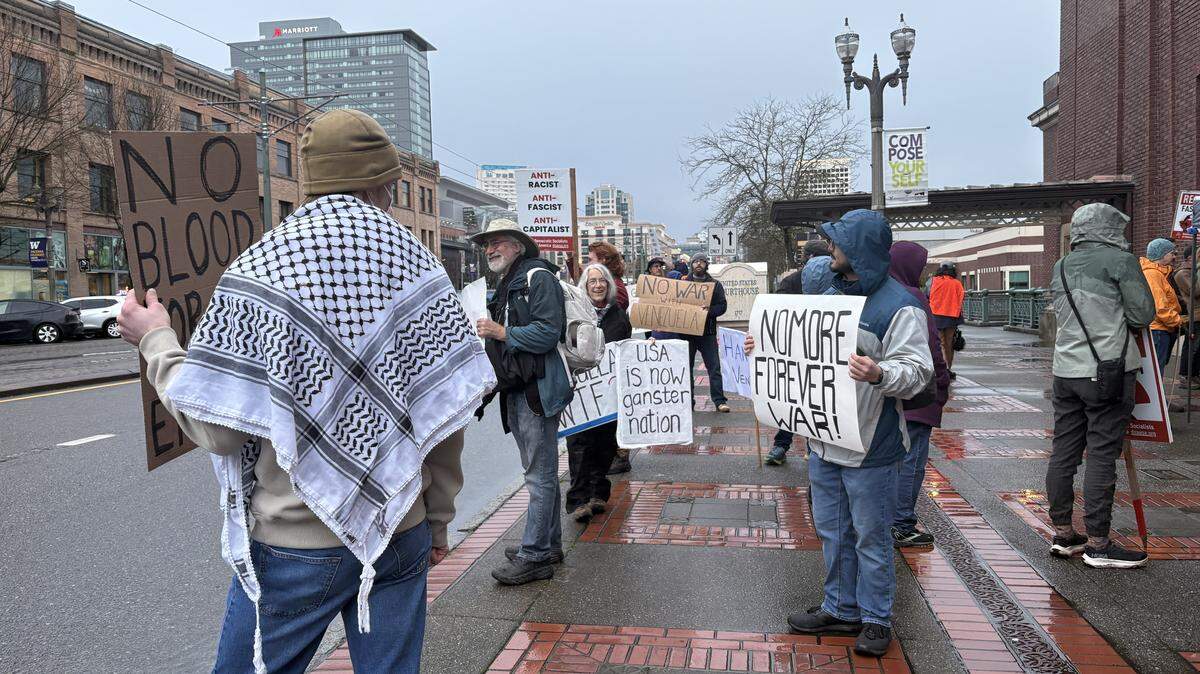 Anti-war protestors hold signs outside the Tacoma courthouse Saturday afternoon during a “Hands Off Venezuela” rally organized by the Tacoma Democratic Socialists of America.