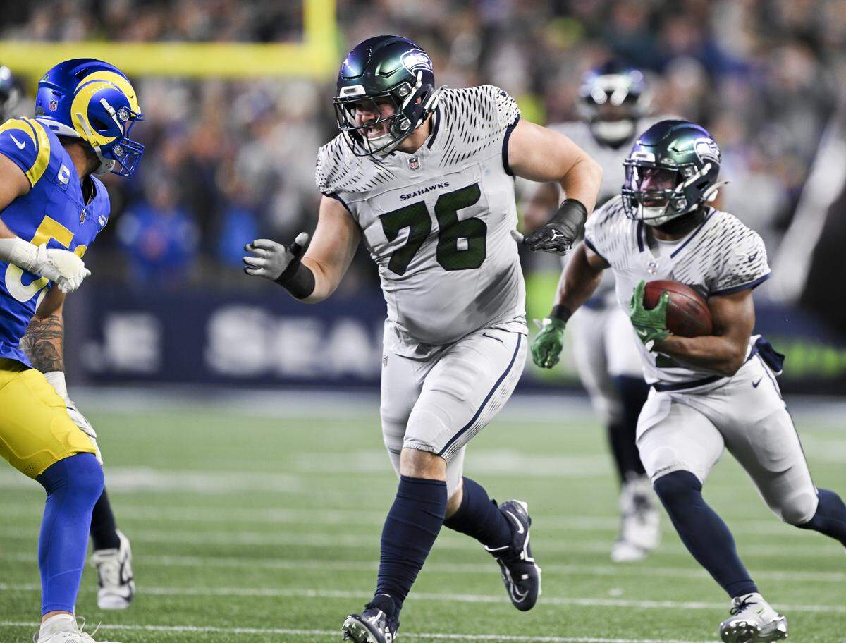 Seattle Seahawks guard Grey Zabel (76) blocks for Seattle Seahawks running back Kenneth Walker III (9) during the first quarter of the game against the Los Angeles Rams at Lumen Field, on Thursday, Dec. 18, 2025, in Seattle.