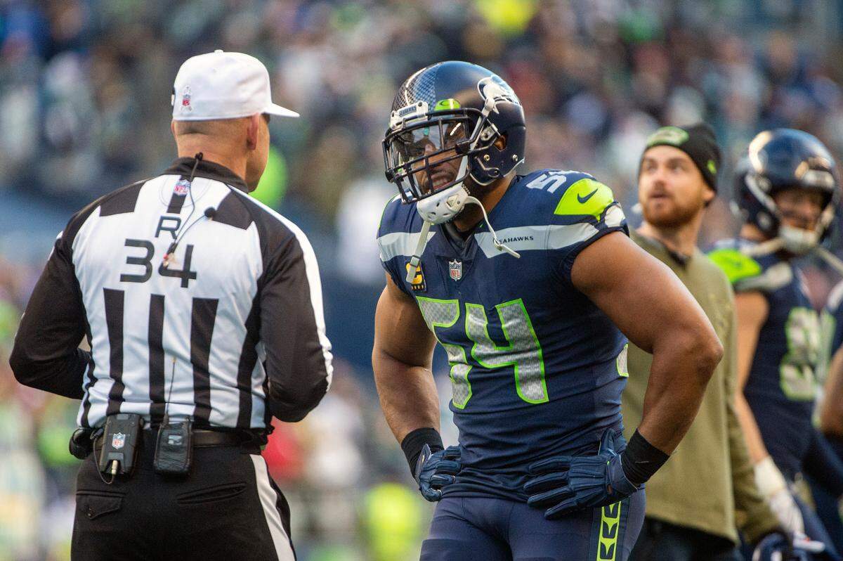 Seattle Seahawks middle linebacker Bobby Wagner (54) talks to an official during a timeout for an official review of and interception by Seattle Seahawks cornerback Sidney Jones (23) during the third quarter of an NFL game on Sunday afternoon at Lumen Field in Seattle.The referee crew was reviewing the interception and return by Seattle Seahawks cornerback Sidney Jones (23). The interception was overruled by the officials and Arizona was retained possession of the ball.