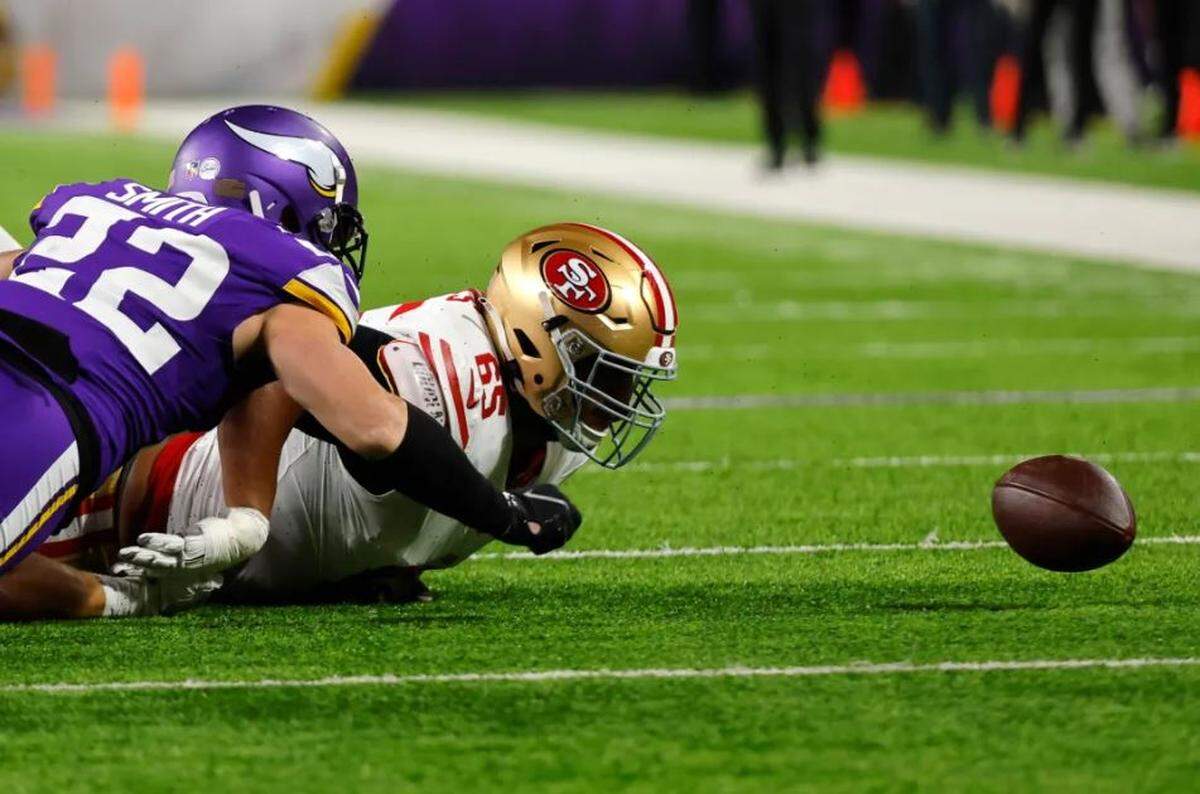 Minnesota Vikings safety Harrison Smith (22) and San Francisco 49ers guard Aaron Banks (65) fight to recover a fumble during the first half of an NFL football game, Monday, Oct. 23, 2023, in Minneapolis.