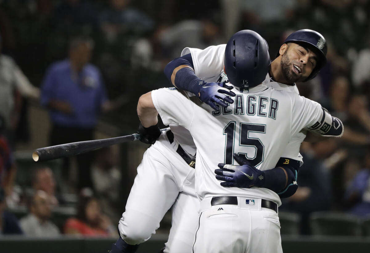 Seattle Mariners’ Nelson Cruz, right, hugs Kyle Seager (15) after Cruz hit a solo home run during the fifth inning of a baseball game against the Baltimore Orioles, Wednesday, Sept. 5, 2018, in Seattle. The homer was back-to-back with one hit by Mariners’ Denard Span. (AP Photo/Ted S. Warren)