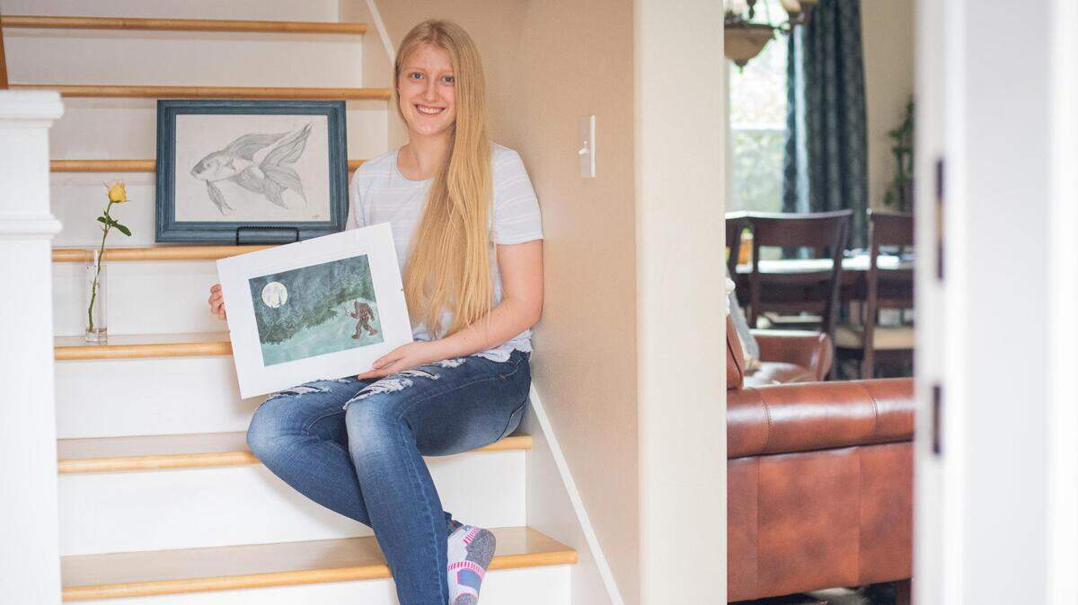Eliana Parks, 15, holds her acrylic painting of Sasquatch reading while sitting for a portrait at home in Gig Harbor, Wash., on Friday, Aug. 21, 2020. Parks’ art will be featured on the new Pierce County Library System cards this year.