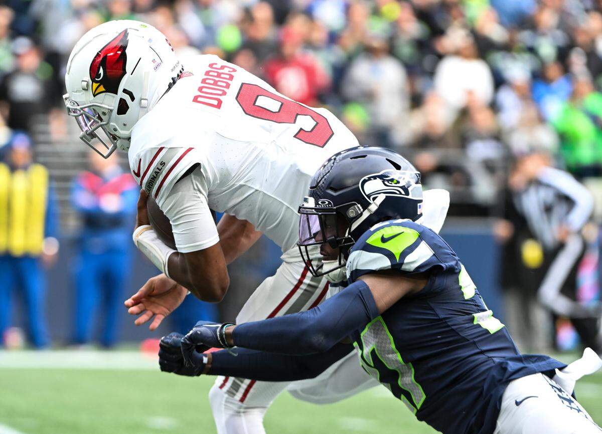Arizona Cardinals quarterback Joshua Dobbs (9) runs in a touchdown during the second quarter of the game against Seattle Seahawks cornerback Devon Witherspoon (21) at Lumen Field, Sunday, Oct. 22, 2023, in Seattle, Wash.