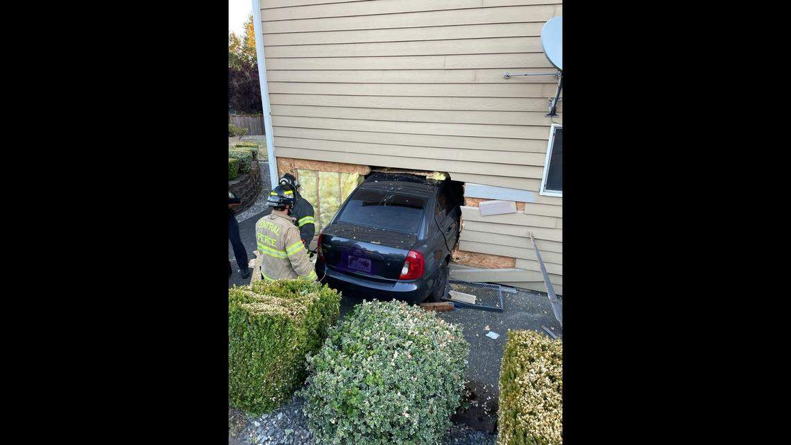 A black sedan is seen embedded in a home in Puyallup after a suspected drunk driver plowed into the house Thursday, July 13.