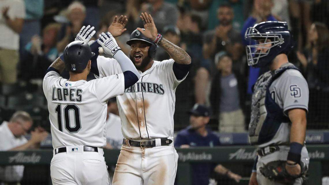Seattle Mariners’ Tim Lopes (10) is greeted at the plate by Domingo Santana, next to San Diego Padres catcher Austin Hedges, after Lopes hit a two-run home run to score Santana during the eighth inning of a baseball game Tuesday, Aug. 6, 2019, in Seattle.