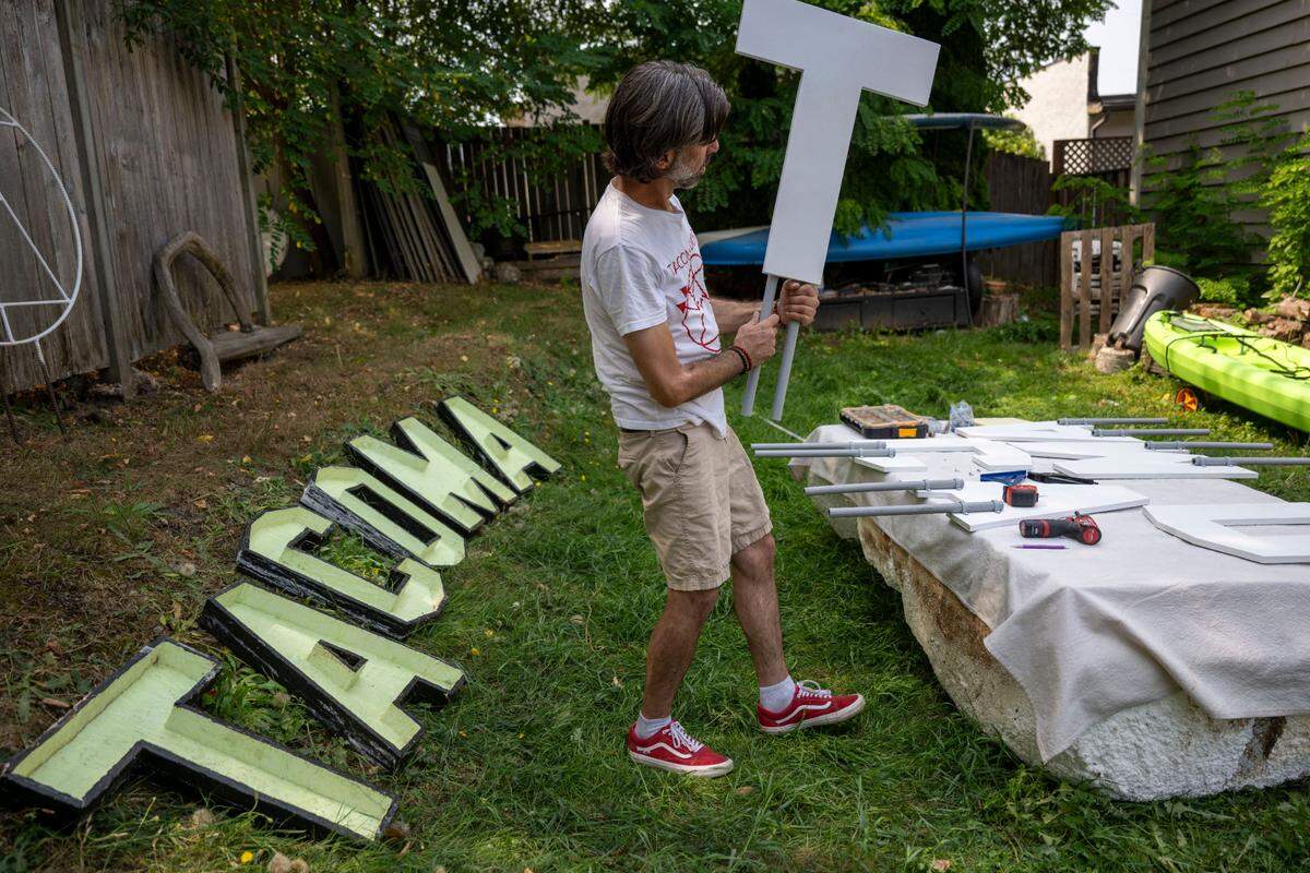 Artist John James Nelson holds a wood “T” that is part of a new “Tacoma” sign that he put up at Titlow Beach on Friday, Aug. 9, 2024, in Tacoma, Wash. The “A” on the previous that sat atop off-shore pilings near the beach recently floated away so he’s decided to rebuild it from scratch.
