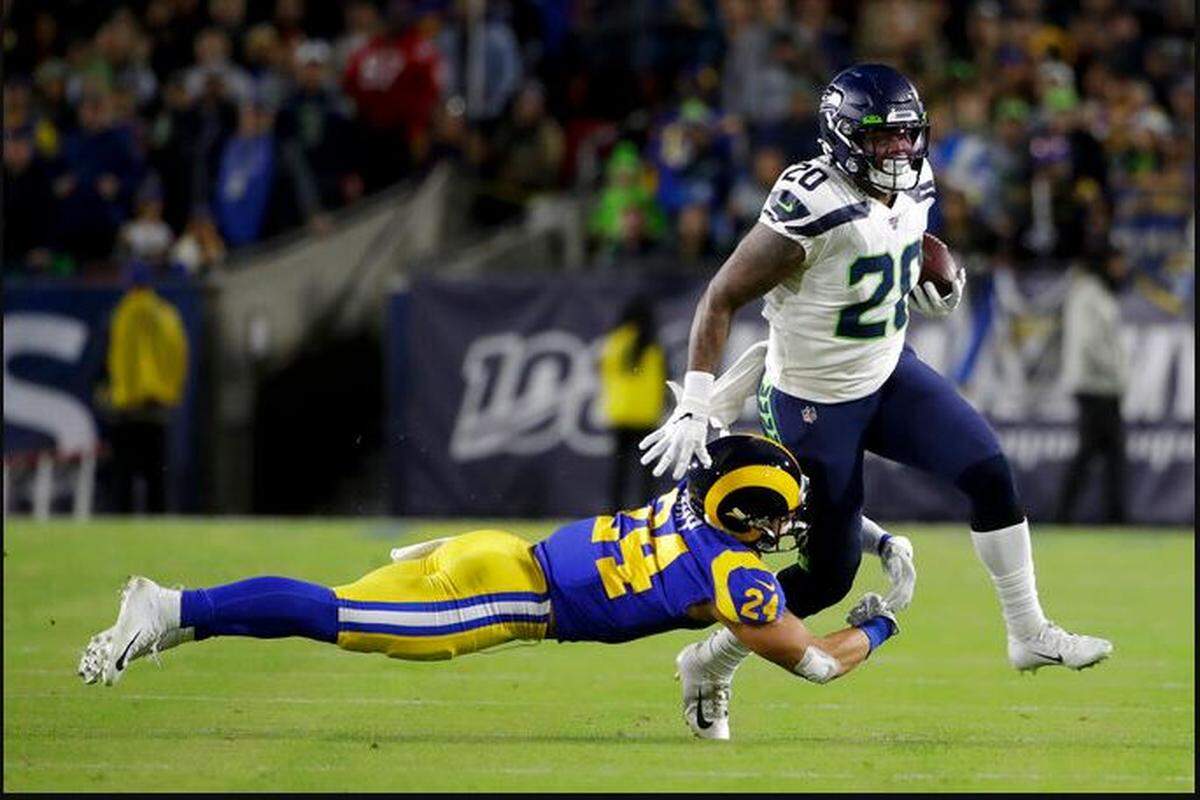 Running back Rashaad Penny injures his left knee after former University of Washington defense back Taylor Rapp (24) tackled him on this 16-yard catch and run early in the Seahawks’ game against the Rams Sunday night at the Los Angeles Memorial Coliseum
