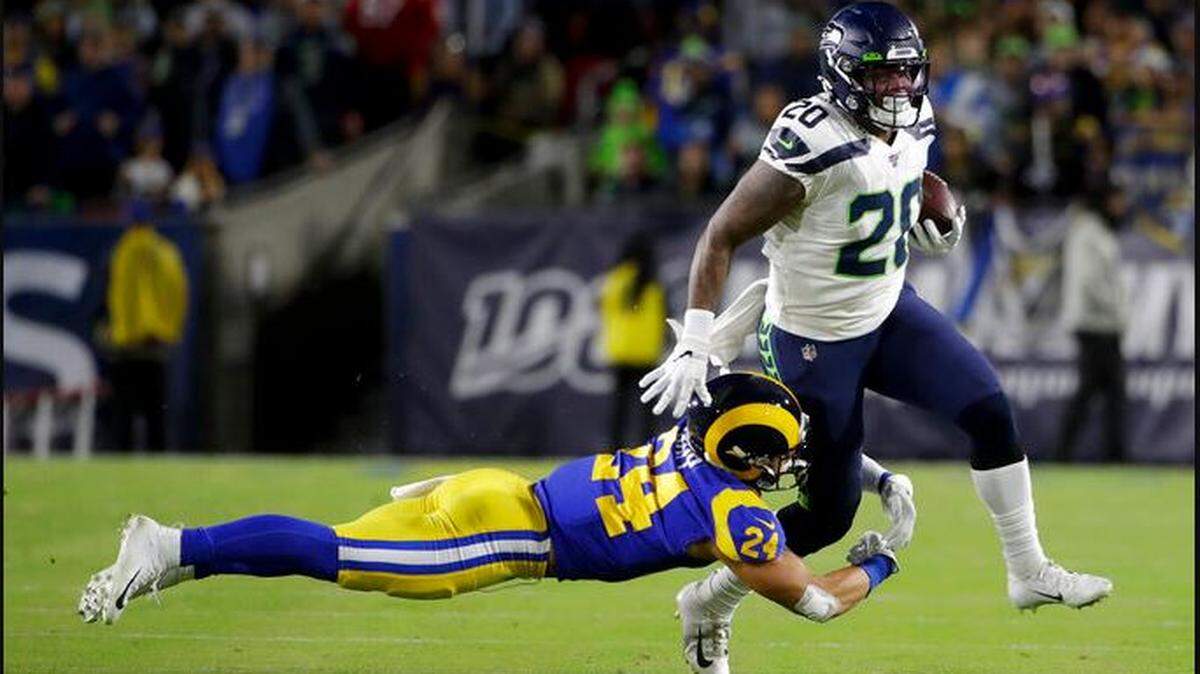 Running back Rashaad Penny injures his left knee after former University of Washington defense back Taylor Rapp (24) tackled him on this 16-yard catch and run early in the Seahawks’ game against the Rams Sunday night at the Los Angeles Memorial Coliseum
