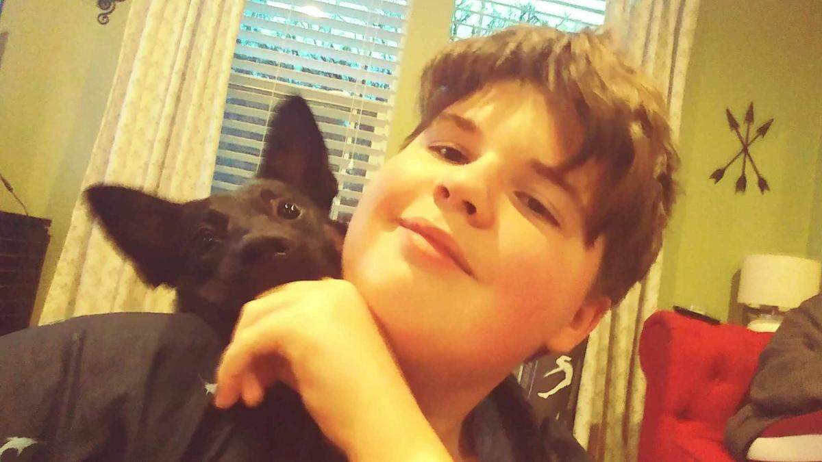 Adrian Gunter, 16, poses with the family’s dog.
