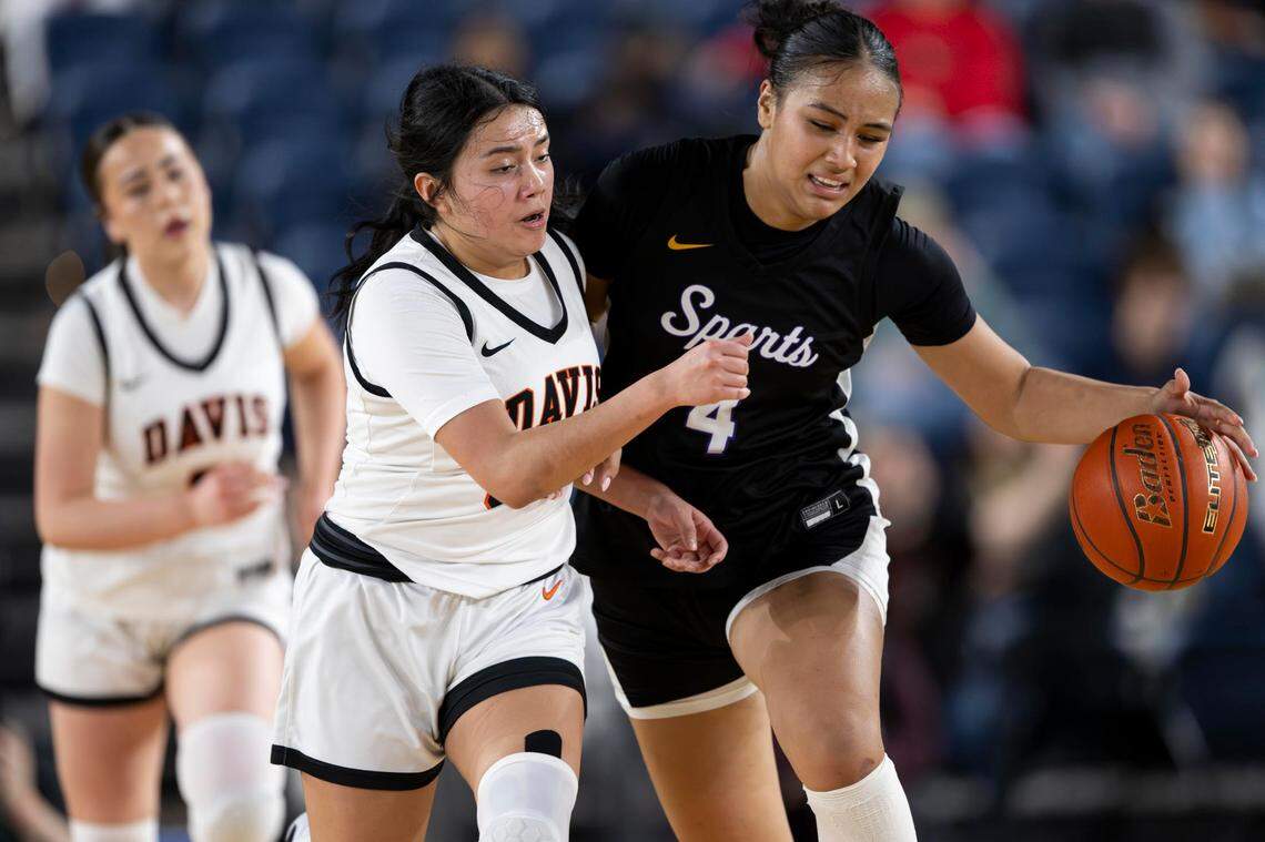 Sumner guard Kawehi Borden (4) dribbles the ball up the court as Davis guard Isa Garcia (33) plays defense during the second quarter of the Class 4A state championship game at the Tacoma Dome on Saturday, March 8, 2025, in Tacoma.