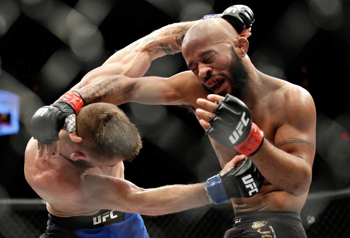 FILE - In this Dec. 3, 2016, file photo, Demetrious Johnson, right, fights Tim Elliott during a mixed martial arts flyweight bout in Las Vegas. Johnson will again defend his flyweight title against Brazilian Wilson Reis in the main event at Sprint Center, the first time the UFC has ventured into Kansas City. (AP Photo/John Locher, File)