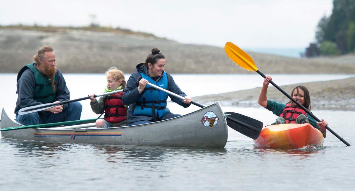 Austin Satterla (from left), Leo O’Callaghan, Kieran O’Callaghan and her son Kieran O’Callaghan paddle through Glen Cove during the Camp Corral military family weekend at YMCA Camp Seymour on the Key Peninsula on Saturday, May 14, 2022.