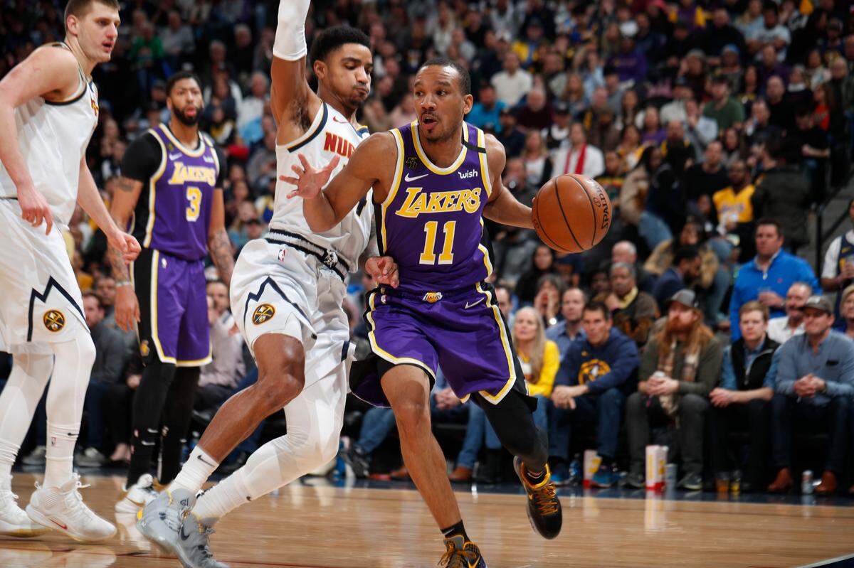 Los Angeles Lakers guard Avery Bradley (11) drives past Denver Nuggets guard Gary Harris (14) in the second half of an NBA basketball game Wednesday, Feb. 12, 2020, in Denver. The Lakers won 120-116 in overtime. (AP Photo/David Zalubowski)