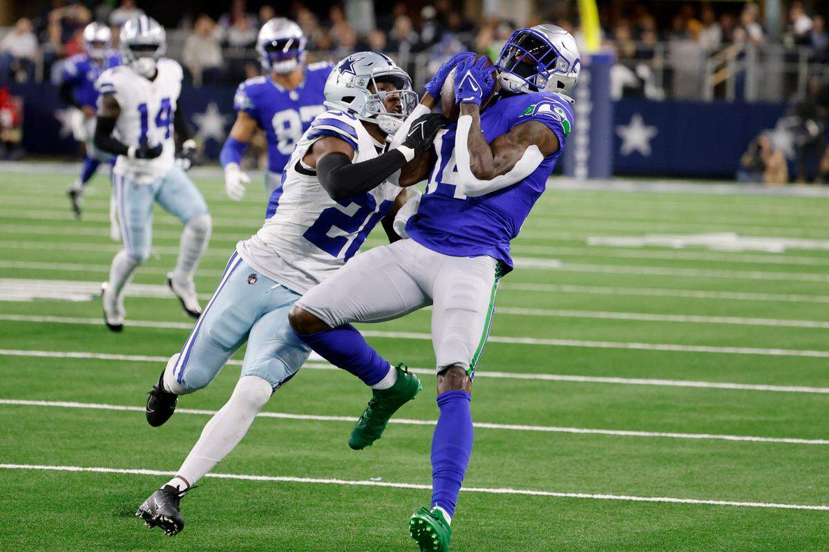 Seattle Seahawks wide receiver DK Metcalf (14) catches a long pass as Dallas Cowboys cornerback DaRon Bland (26) defends in the first half of an NFL football game in Arlington, Texas, Thursday, Nov. 30, 2023. (AP Photo/Michael Ainsworth)
