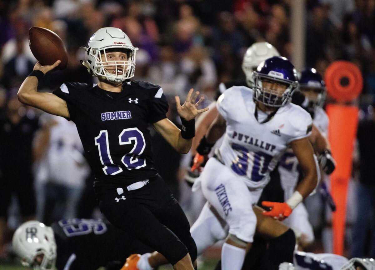 Sumner’s Griffin Clark throws a pass under pressure in the third quarter. Sumner High School played Puyallup High School in a football game at Sunset Chev Stadium in Sumner, Wash., on Thursday, Sept. 19, 2019.