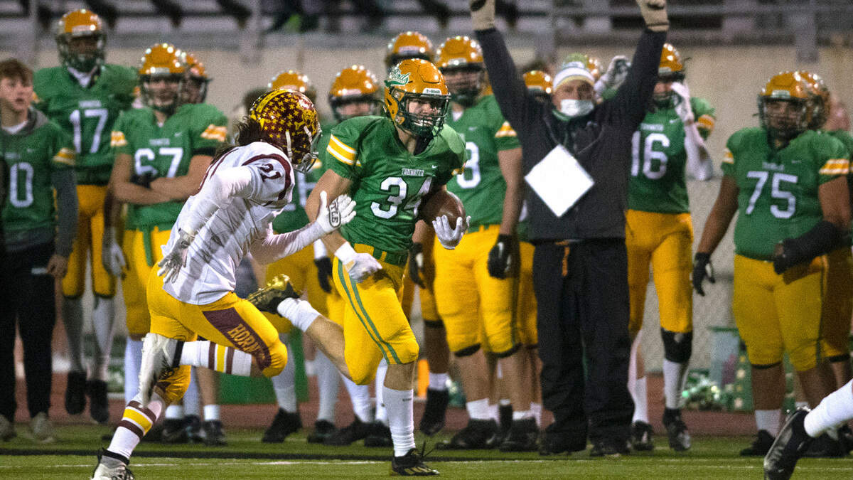 Tumwater punt returner Payton Hoyt breaks loos up the sideline in front of Enumclaw defender Emmit Otero for a punt return for a touchdown during Friday night’s 2A football state quarterfinal game at Tumwater District Stadium in Tumwater, Washington, on Nov. 19, 2021.