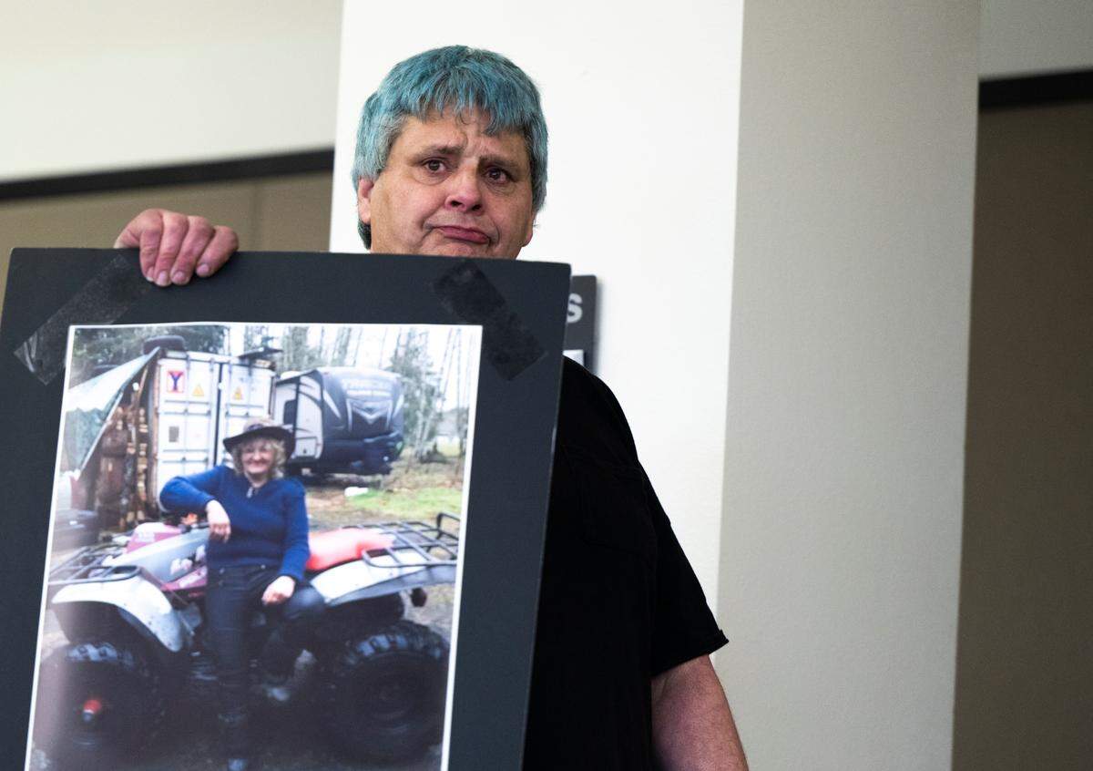 Jason Keel, husband of victim Jeaneane Mattis, holds up a photo of his wife during the sentencing of Paul Michael Snider, 29, for murdering three people in Tacoma between Sept. 4 and Nov. 21, 2022, at Piece County Superior Court, on Friday, April 12, 2024, in Tacoma, Wash. Snider pleaded guilty to two counts of second-degree murder and one count of first-degree murder.