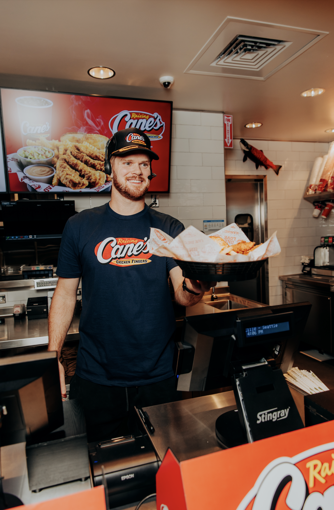Seahawks Super Bowl-winning quarterback Sam Darnold “serving” chicken fingers to “customers” at a soft opening for a new Raising Cane’s chicken joint in the University District of Seattle, Tuesday, Feb. 10, 2026.