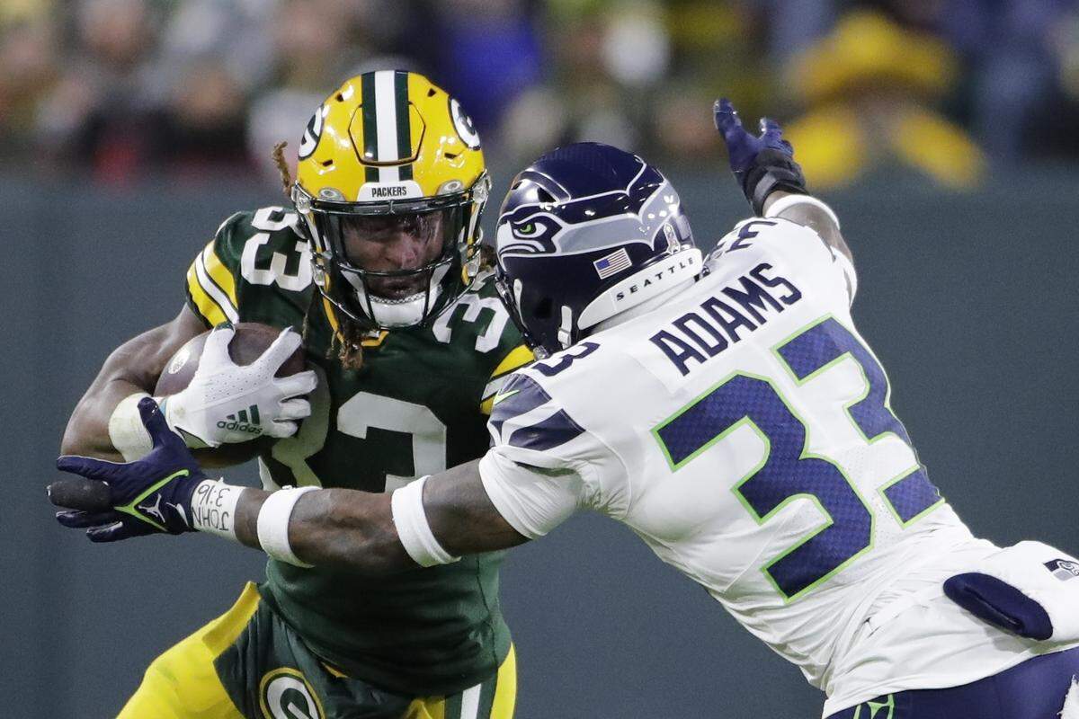 Green Bay Packers’ Aaron Jones tries to get past Seattle Seahawks’ Jamal Adams during the first half of an NFL football game Sunday, Nov. 14, 2021, in Green Bay, Wis. (AP Photo/Aaron Gash)