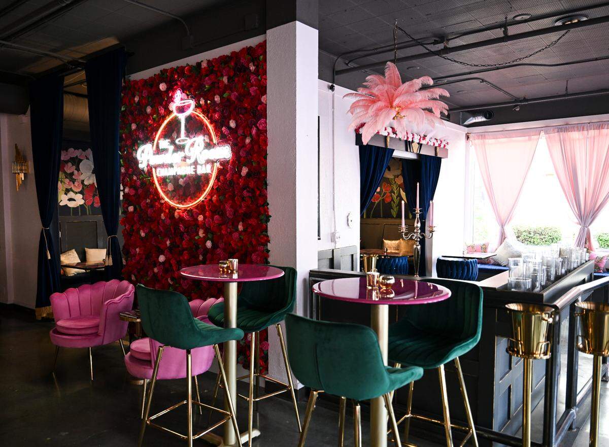 Pink mingles with jewel tones, from cozy velvet chairs to Instagram-ready flower walls. The first thing Smith and Gilmore purchased for the space was this pastel-pink feather chandelier.