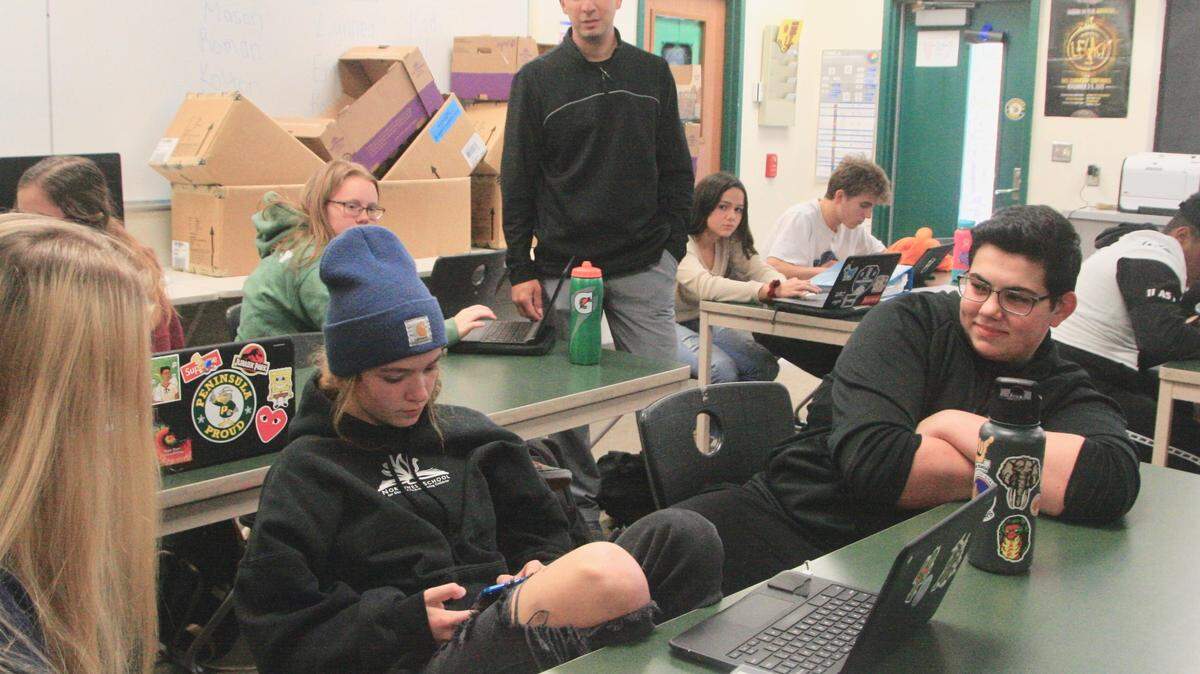 A gathering of AVID students at Peninsula High is under guidance of Matt Robles, AVID 11 Instructor, center, standing.