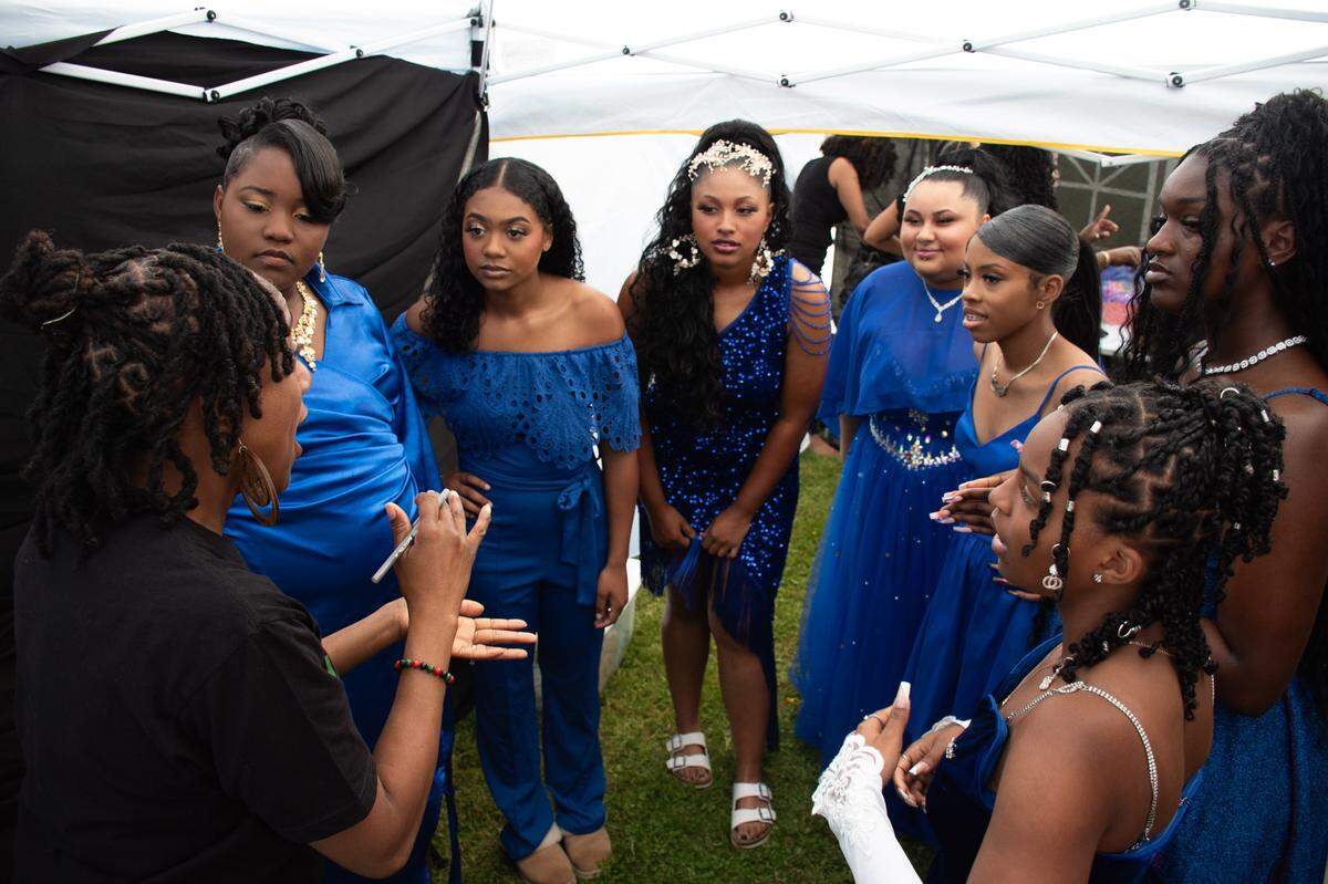 Contestants of the 2024 Miss. Juneteenth Pageant huddle around to listen to last-minute changes to the choreography before taking the stage during the Juneteenth Celebration held in Stewart Heights Park on Wednesday, June 19, 2024, in Tacoma.