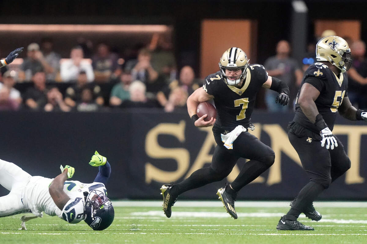 New Orleans Saints’ Taysom Hill breaks the tackle of Seattle Seahawks safety Quandre Diggs and heads to the end zone for a 60 yard rushing touchdown during an NFL football game in New Orleans, Sunday, Oct. 9, 2022. (AP Photo/Gerald Herbert)