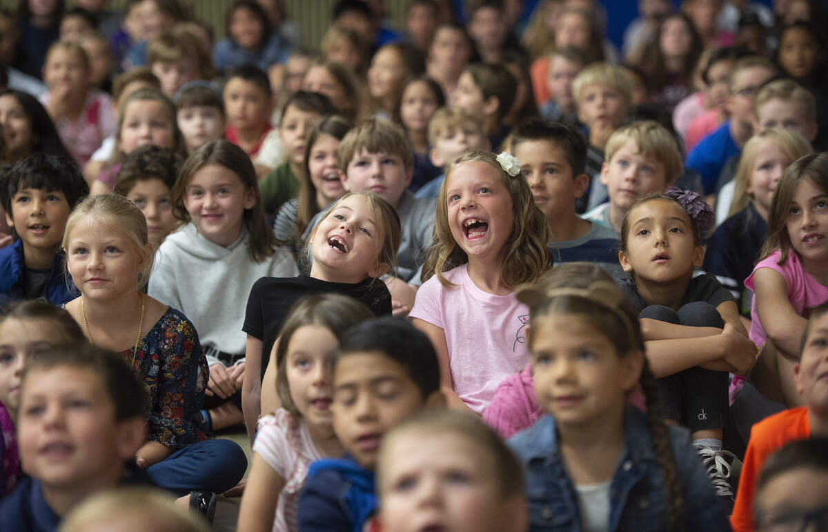 Taylor Cain (left) and Olivia Fordham, 7-year-old second graders at Purdy Elementary in Gig Harbor, watch a welcome back video from the teachers during an assembly on the first day of school in the Peninsula School District on Wednesday, Aug. 29, 2018.