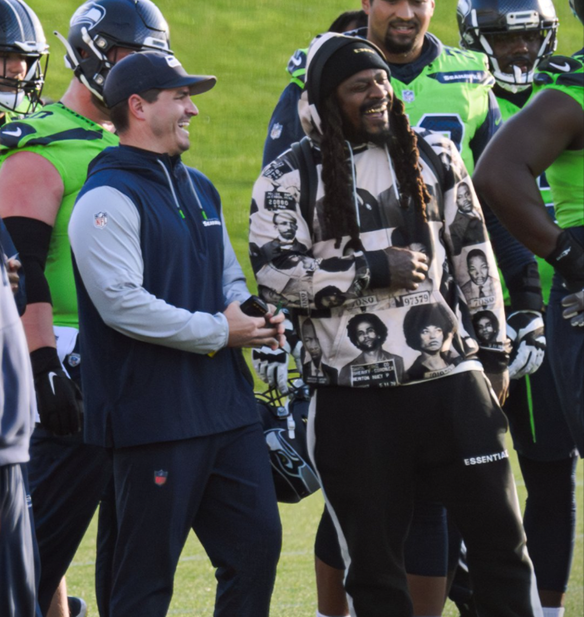 Marshawn Lynch laughs with coach Mike Macdonald at Seattle Seahawks practice Nov. 11, 2024, at the Virginia Mason Athletic Center in Renton. The team legend and retired, Super Bowl-winning running back has been around the Seahawks multiple times this 2024 season.