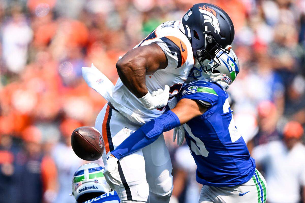 Seattle Seahawks safety Julian Love (20) bats out the ball from Denver Broncos running back Audric Estime (23) as he hurdles cornerback Riq Woolen (27) during the second quarter of the game at Lumen Field, on Sunday, Sept. 8, 2024, in Seattle, Wash.