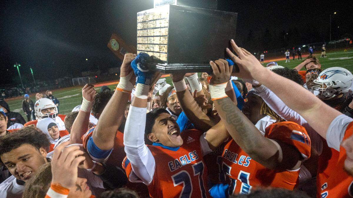 Graham Kapowsin players hoist the State 4A championship trophy on Saturday afternoon after beating Lake Stevens, 44-7, at Mount Tahoma Stadium in Tacoma.