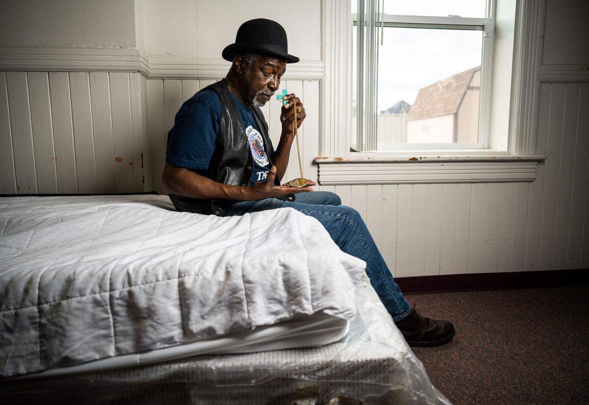 Former boxer and 1972 Olympic gold medalist Sugar Ray Seales holds his gold medal as he sits on a bed in the Shiloh Baptist Church where he is currently living in Tacoma, Wash. on March 29, 2023. Seales fell into homelessness after moving back to his home city of Tacoma after his wife passed away in February 2022.