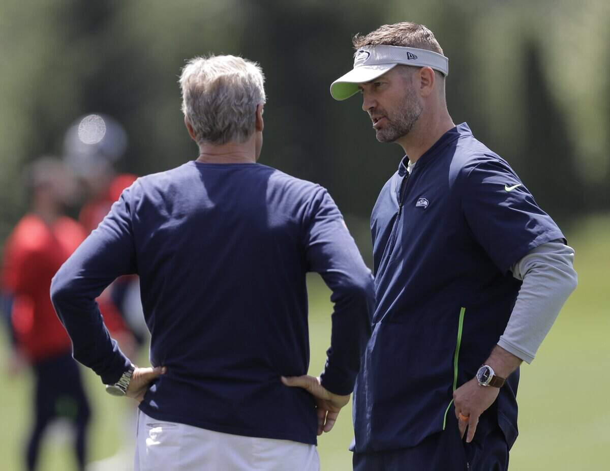 Seattle Seahawks offensive coordinator Brian Schottenheimer, right, talks with head coach Pete Carroll, left, following an organized team activity, Tuesday, June 4, 2019, at the team’s NFL football training facility in Renton, Wash. (AP Photo/Ted S. Warren)