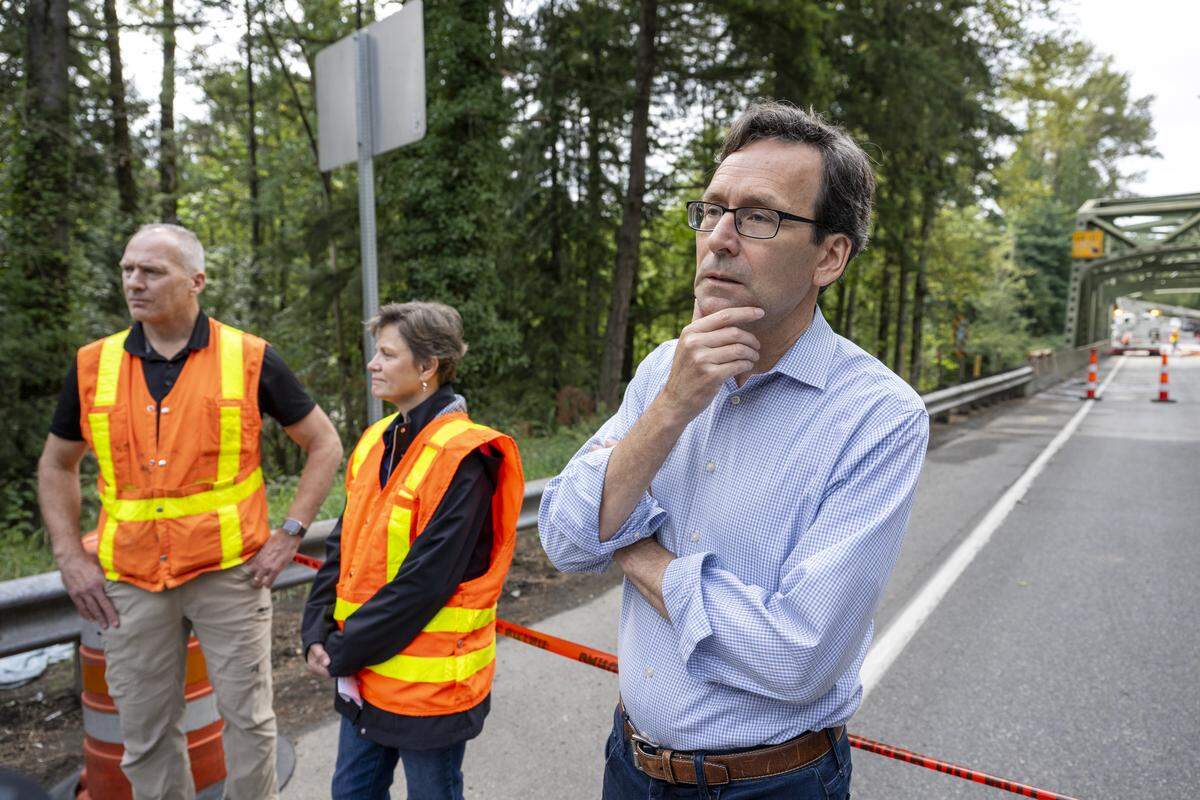 Gov. Bob Ferguson, right, listens to questions from the community during a visit to the White River Bridge on Monday, Sept. 8, 2025, in Enumclaw. A Pierce County man has been charged with allegedly threatening the governor.