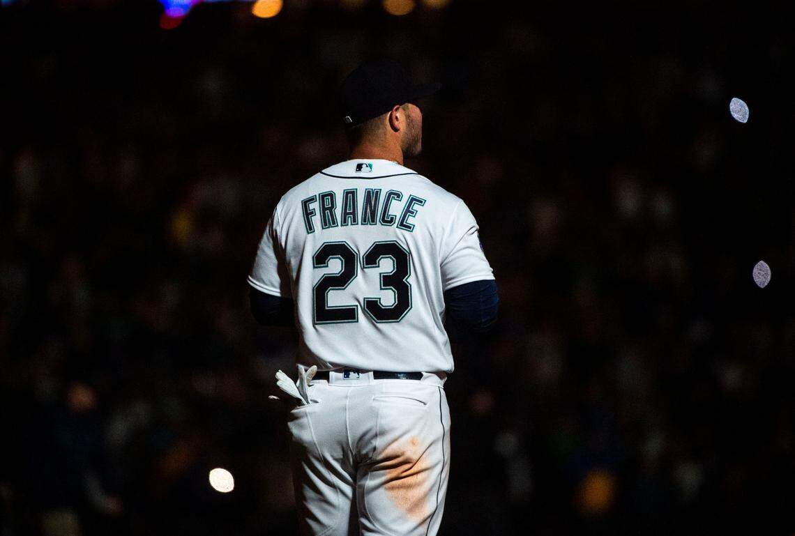 Seattle Mariners first baseman Ty France (23) stands on the field as the lights dim during the eighth inning of the Mariners home opener against the Cleveland Guardians at T-Mobile Park in Seattle on Thursday, March 30, 2023. Mariners won 3-0.