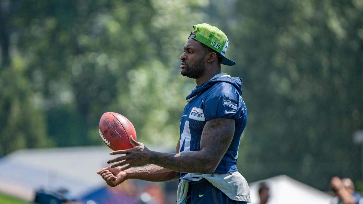 Seattle Seahawks wide receiver DK Metcalf handles the ball as he watches instead of practices on the first day of training camp at the Virginia Mason Athletic Center in Renton on July 27, 2022.