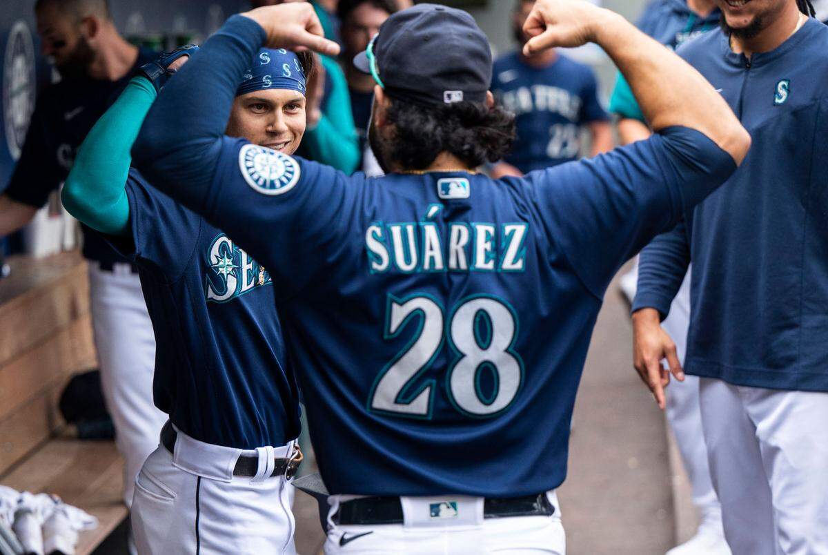 Seattle Mariners right fielder Sam Haggerty (0) and Seattle Mariners third baseman Eugenio Suarez (28) flex in the dugout after Haggerty hit a home-run in the sixth inning of the game at T-Mobile Park in Seattle, Wash. on August 10, 2022. The Mariners defeated the Yankees 4-3. 