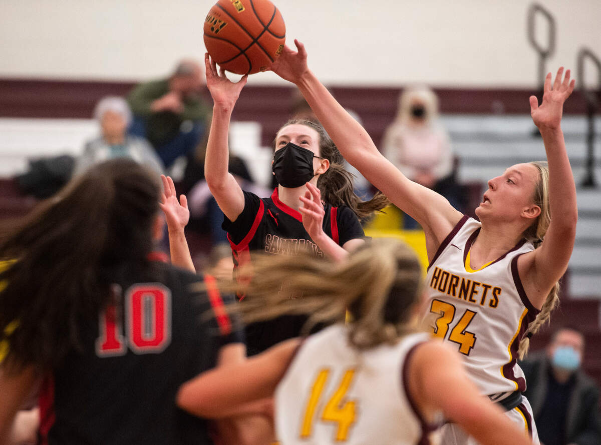 Sammamish Totems’s forward Sarah Skaggs (12) jumps to shoot the ball as White River Hornet’s forward Vivian Kingston (34) tries to block her during the high school girls basketball state tournament regional round game at Mount Tahoma High School in Tacoma, Wash. on Friday, Feb. 25, 2022.