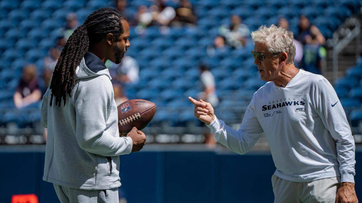 Richard Sherman talks to Seattle Seahawks coach Pete Carroll at Lumen Field before the Seahawks’ practice game on Saturday Aug. 6, 2022 in Seattle, Wash.