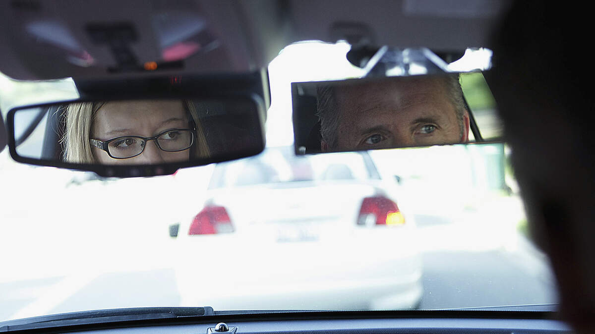 A high school driver, left, checks her mirror during driving time with her driver education instructor in DelKalb, Illinois. (AP Photo/Daily Chronicle, Danielle Guerra)