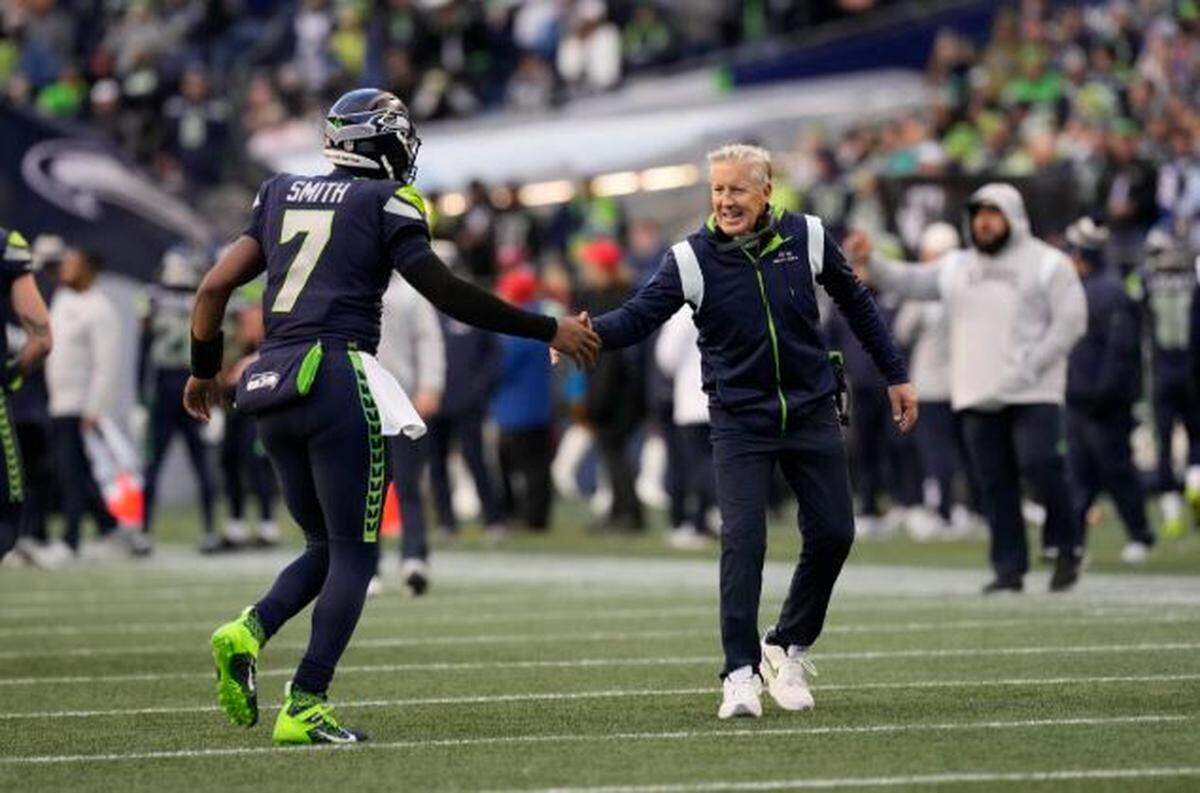 Seattle Seahawks quarterback Geno Smith and head coach Pete Carroll shake hands during a game against the Las Vegas Raiders on Nov. 27, 2022, in Seattle. Carroll said Feb. 28, 2023, at the NFL scouting combine in Indianapolis he expected the Seahawks to get a new contract done with Smith soon.