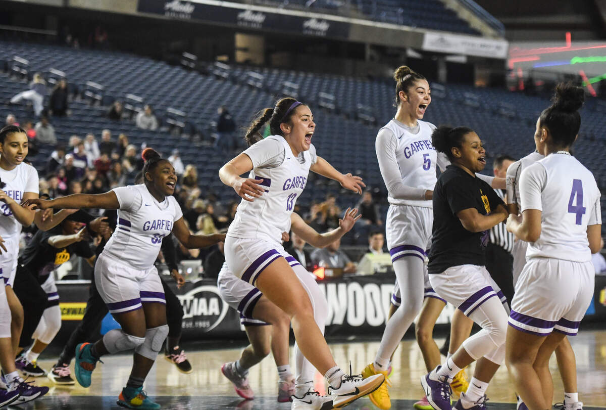 Garfield players celebrate their state title win. Garfield played Lake Washington in the 3A Girls championship game at the Hardwood Classic state basketball tournament at the Tacoma Dome in Tacoma, Wash., on Saturday, March 7, 2020.