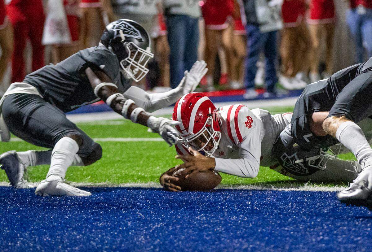 Mater Dei quarterback Bryce Young scores in the first quarter against St. John Bosco defenders at St. John Bosco High School in Bellflower, Calif., on Oct. 25, 2019.