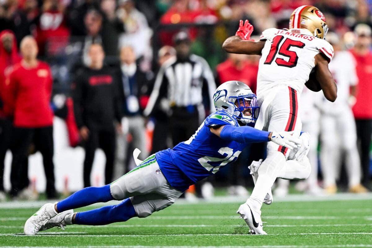 Seattle Seahawks safety Julian Love (20) dives on San Francisco 49ers wide receiver Jauan Jennings (15) during the third quarter of the game at Lumen Field, on Thursday, Oct. 10, 2024, in Seattle, Wash.