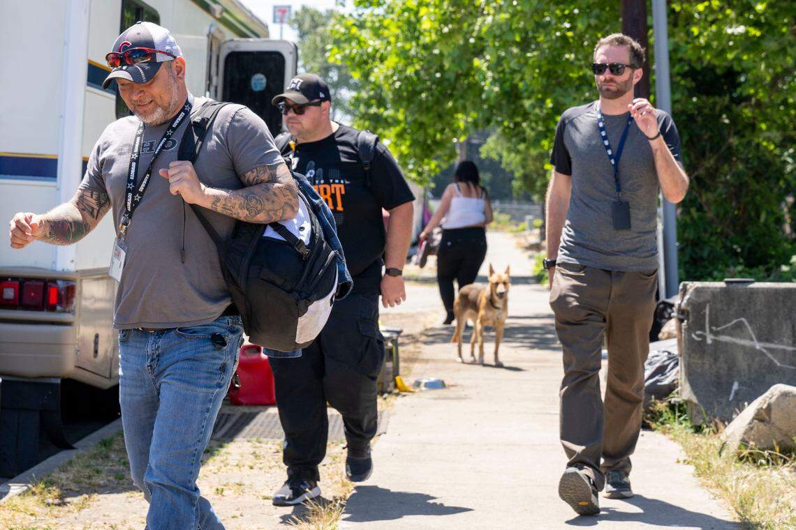 After helping with medical problems and giving out supplies to people living along South Trafton Street, members of a Greater Lakes Homeless Outreach and Stabilization Team Glen Kelly (left), Brandon Rabisa (center) and Elliott Bagwell, a nurse practitioner, walk back to their van on Tuesday, June 6, 2023, in Tacoma, Wash.