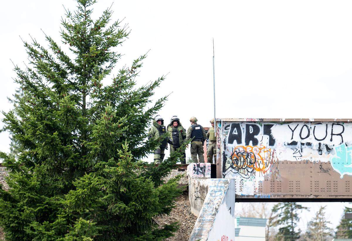 A bomb squad investigates a reported grenade that a man was holding when he was shot and killed by Pierce County deputies, on the train tracks near the corner of 112th Street East and Portland Avenue on March 24, 2023. No officers where injured.