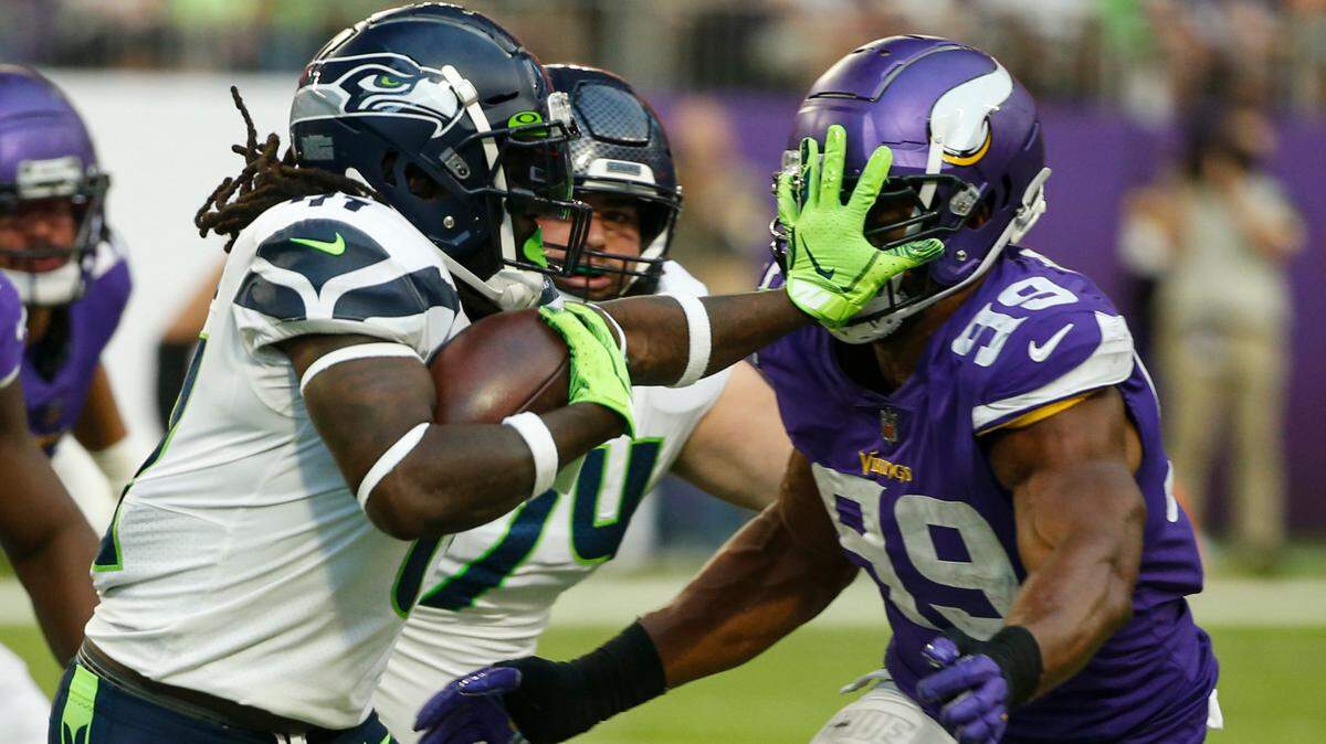 Seattle Seahawks running back Alex Collins (41) pushes off Minnesota Vikings defensive end Danielle Hunter (99) as he runs in the second half of an NFL football game in Minneapolis, Sunday, Sept. 26, 2021. (AP Photo/Bruce Kluckhohn)